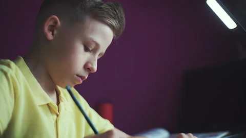Little boy does homework, writes useful information. Slow Motion. Video stock 132034414