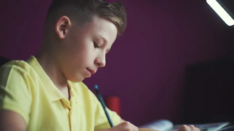 Little boy does homework, writes useful information. Slow Motion. Video stock 132034546