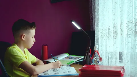 Little boy does homework, writes useful information. Slow Motion. Stock Footage 132056137