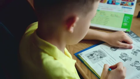 Little boy does homework, writes useful information. Slow Motion. Video stock 132056551