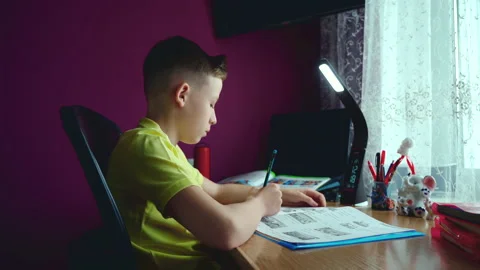Little boy does homework, writes useful information. Slow Motion. Video stock 132057191