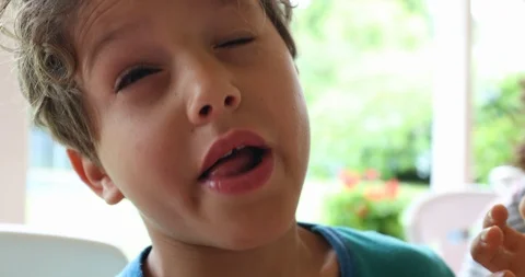 Little boy doing digust face and funny grimace and then taking a bite from fo Stock Footage 117354683