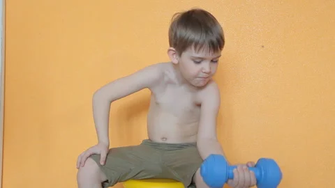 Little boy doing dumbbell exercises on biceps, triceps Stock Footage 106390201