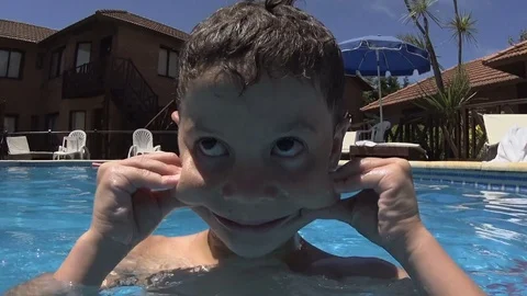 Little Boy doing funny faces, diving &amp; Playing in Swimming Pool Stock Footage 84066187