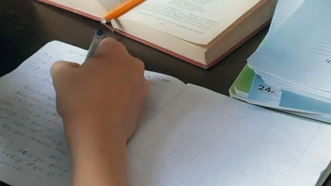 Little boy doing homework. He sits at his desk, learning to write letters Stock Footage 69865361