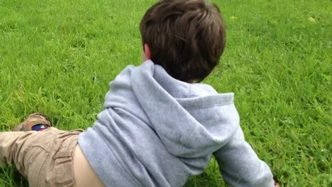 Little Boy Doing Rolly Pollies Down A Hill Stock Footage 72380188