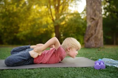 Little boy doing stretch during workout outdoors Foto stock