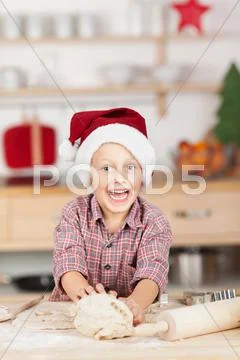 Little boy with dough at kitchen counter Stock Photos