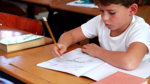 Little boy drawing in notepad in classroom Stock Footage 40397571