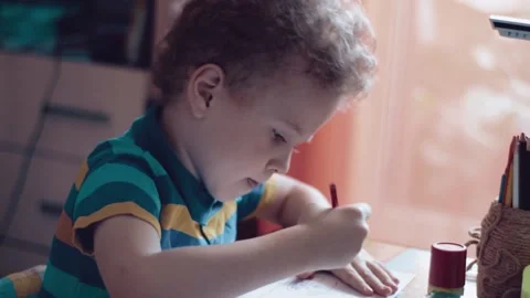 Little boy draws at a table at home Stock Footage 142704456