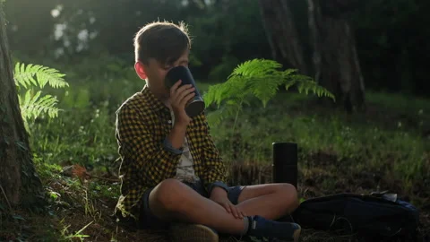 Little boy drinking hot tea from a thermos on a sunny day. Stock Footage 135346847