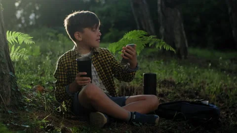 Little boy drinking hot tea and making video on phone on a sunny day. Video stock 147290164