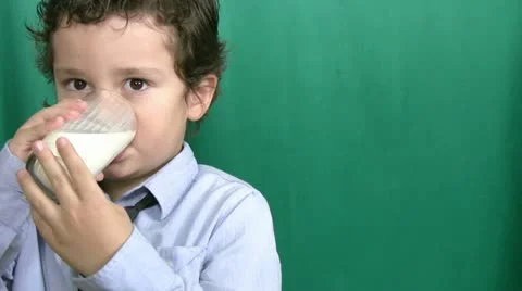 Little boy drinking milk on green screeen Stock Footage