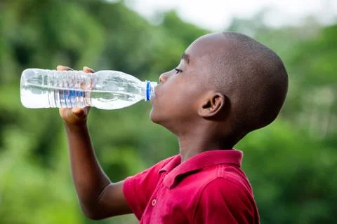 Little boy drinking mineral water outdoors Stock Photos