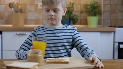Little boy drinking orange juice at breakfast on the kitchen Stock Footage 101103789