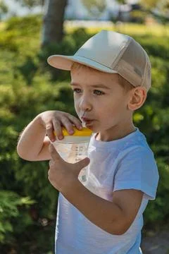 A little boy drinks water while resting between meals on a bicycle Stock Photos
