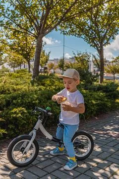 A little boy drinks water while resting between meals on a bicycle Stock Photos