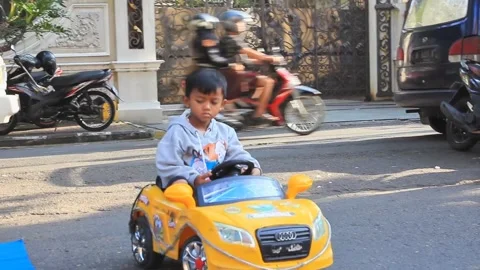 Little boy driving a yellow remote control car Stock Footage 286403233