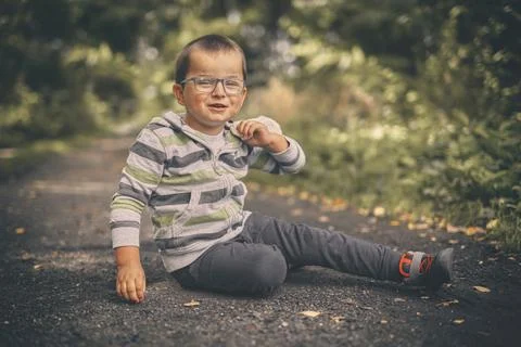 Little boy on dusty path training classic marbles outdoor on pathway in natur Stock Photos