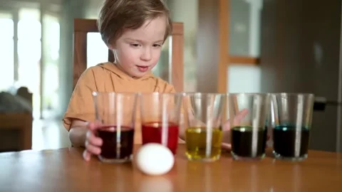 Little boy dyeing Easter eggs at home. Slow motion footage 스톡 동영상 302175163