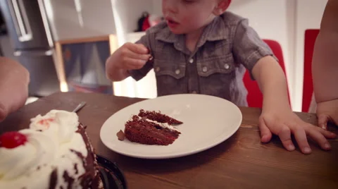 Little boy eating a cake at table Stock Footage 64454115