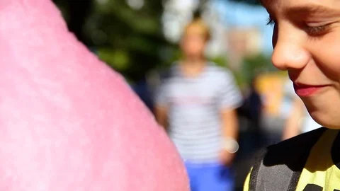 Little boy eats cotton candy at an amusement park. Video stock 117939708
