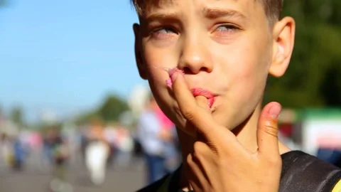 Little boy eats cotton candy at an amusement park. Video stock 117939717