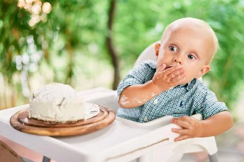 Little boy eats cream from cake Stock Photos