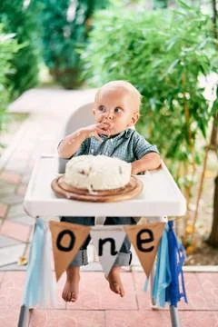 Little boy eats cream from cake with his hands Stock Photos