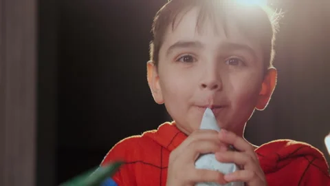 A little boy eats icing from a pastry bag. Stock Footage 291757930