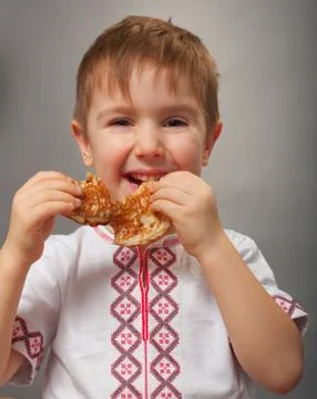 Little boy eats pancakes Stock Photos