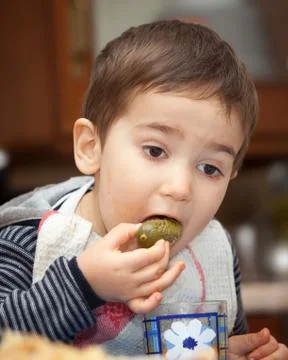 Little boy eats pickles Stock Photos