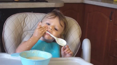 Little boy eats porridge for breakfast Stock Footage 81243370