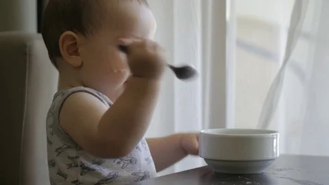 A little boy eats porridge himself. 4K, Stock Footage 80194209
