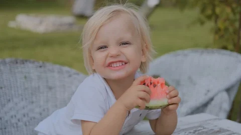 Little boy eats watermelon and cute smiles while looking at the camera Stock Footage 116049692