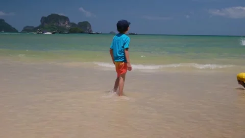 Little boy enjoying ocean, playing in waves, happy emotions during vacation Stock Footage 252035524