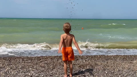 Little Boy Explores Pebbles by the Black Sea Shore in Crimea Video stock 312554041