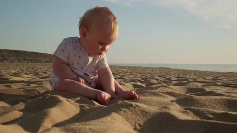 Little boy exploring the world on sand beach against  a blue ocean. Vídeos de archivo 305828792
