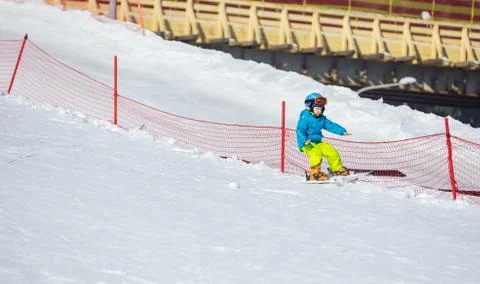 Little boy falling down while skiing in children's area Stock Photos