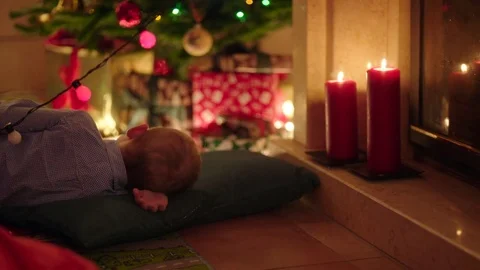 Little boy felling asleep while waiting Santa Claus on Christmas night near Stock Footage 73047240