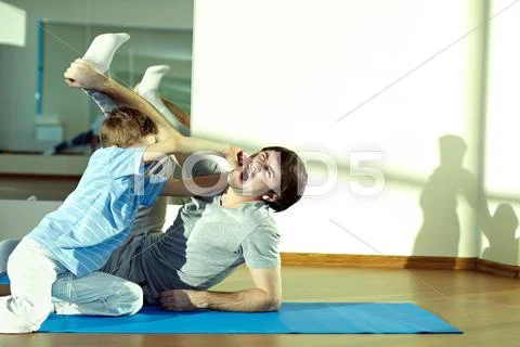 Little boy fighting with his father in gym Stock Photos