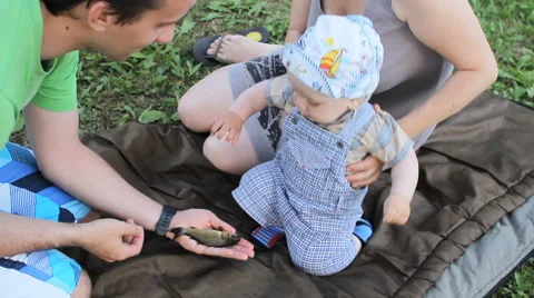 The little boy the first time touching a live fish. He takes her hand and Stock Footage 64852233