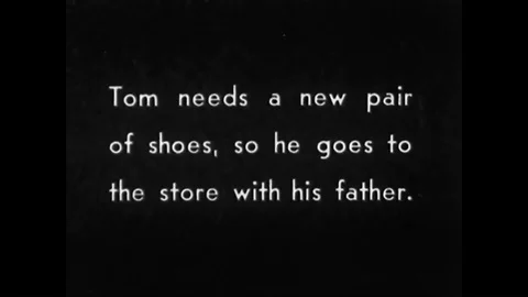 A little boy is fitted for a new pair of shoes at a shoe store in 1922. Stock Footage 99361473