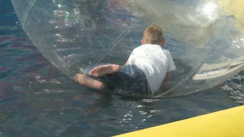 Little boy flounders inside a big inflatable ball Видео 71897692