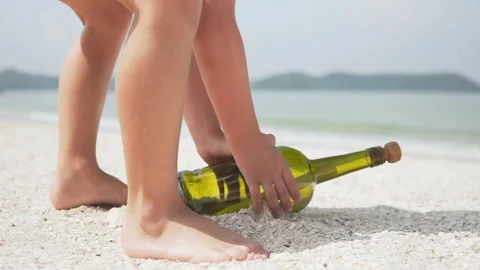Little boy is founding a message in a bottle (MIB) Video stock 250498296