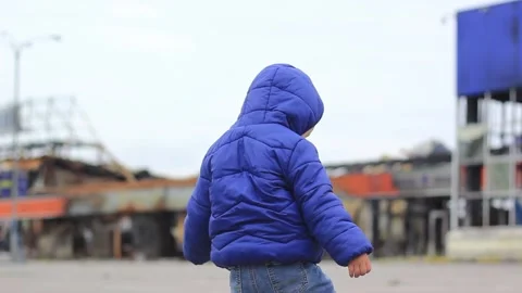 A little boy in front of a destroyed building during the fighting, view from the Stock Footage 211059901