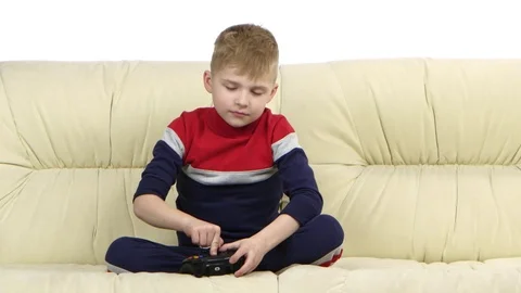 Little boy with games console playing video game on couch Stock Footage 75918827