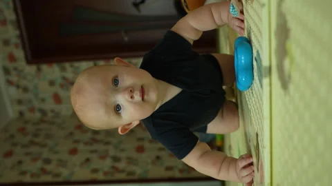 The little boy gets down on all fours, sways and tries to crawl. Stock Footage 252038931