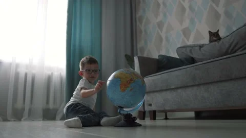 A little boy with glasses studying globe. Education at Home. Stock Footage 130838080