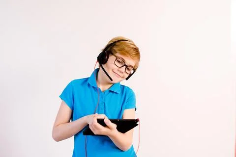 Little boy in glasses using a tablet computer with a light background Stock Photos